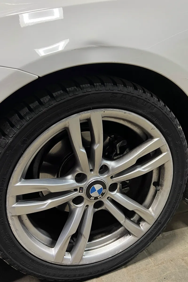 Вмятина на переднем крыле BMW над колёсной аркой — до ремонта